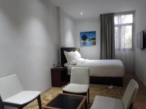 une chambre d'hôtel avec un lit et deux chaises dans l'établissement Yatu International Hotel, à Dirē Kʼalu