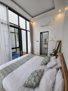 a bedroom with a large bed with a large window at Mai House Jogja in Piyungan +24 photos