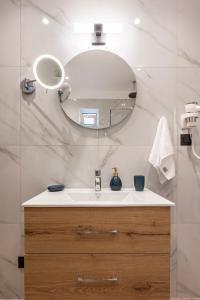 une salle de bain avec un lavabo et un miroir dans l'établissement The Saltwater Suite 1 minute Beach, à Kos