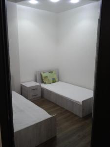 a white room with two beds and a mirror at Mari Apartment in Batumi