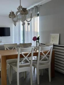 a dining room table with white chairs and a chandelier at Agroturystyka BM Horse in Tągowie