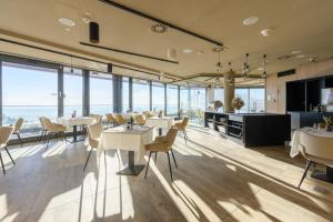 Um restaurante com mesas e cadeiras e vista para o oceano. em Hotel Princeps em Sátoraljaújhely