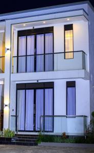 a white house with large windows at Serene 1bed, 1bath studio Apartment in Mbarara