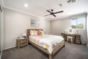 a bedroom with a bed and a desk at Luxury at Lagoon Estate in Nelson Bay
