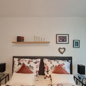 ein Schlafzimmer mit einem Bett mit Kissen darauf in der Unterkunft Einladend Graz in Graz + 47 Fotos