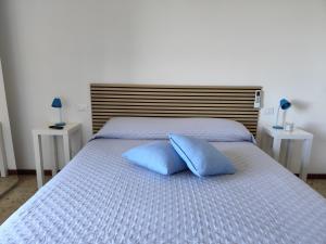une chambre avec un lit avec deux oreillers bleus dessus dans l'établissement Siena Alta, Ospitalità con Vista, à Sienne 12 autres photos