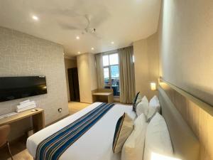 a hotel room with a bed and a tv at Bluestone Prime by The Cosy Hotels in New Delhi