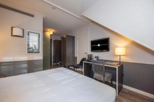 une chambre avec un lit, un bureau et une télévision dans l'établissement Fletcher Hotel - Restaurant Nautisch Kwartier, à Huizen