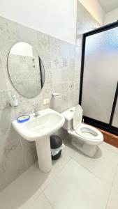 a bathroom with a sink and a toilet and a mirror at Habitación doble # 3 in Macas