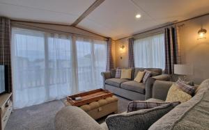 a living room with two couches and a tv at The Good Life, The Boulevard, Selsey in Selsey