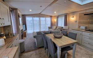 a kitchen and living room with a table and a couch at The Good Life, The Boulevard, Selsey in Selsey