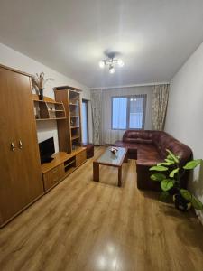 a living room with a leather couch and a table at Апартамент Радост in Bansko