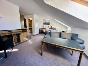 a living room with a blue couch and a bed at Hotel Residenz in Bad Neustadt an der Saale