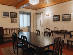 ein Esszimmer mit einem Holztisch und Stühlen in der Unterkunft A Vista dos Verdes in Furnas