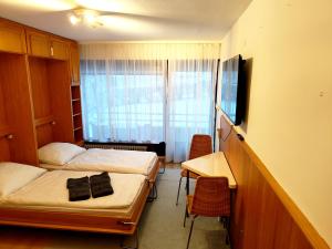 ein Zimmer mit zwei Betten und einem Schreibtisch und einem Fenster in der Unterkunft Bad Gastein Holiday Apartments in Bad Gastein