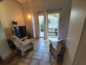 巴利托Guest house on Gillian UNIT 2的有两把椅子和一台电视的客厅