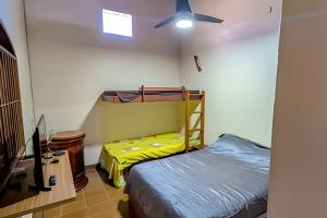 ein Schlafzimmer mit einem Bett und einem Deckenventilator in der Unterkunft Conforto e praia a poucos passos in Guriri + 2 Fotos