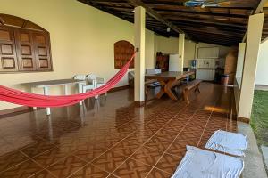 eine Hängematte in der Mitte eines Wohnzimmers in der Unterkunft Conforto e praia a poucos passos in Guriri