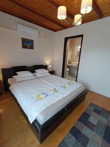 une chambre avec un grand lit avec des draps et des oreillers blancs dans l'établissement Szilvia Panzió Gyomaendrőd, à Gyomaendrőd