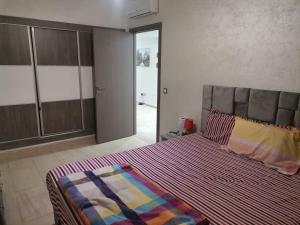 1 dormitorio con 1 cama con edredón a rayas en Central Park, en Mohammedia