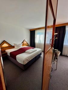 a bedroom with a bed and a desk and a chair at Hotel Residenz in Bad Neustadt an der Saale +31 photos