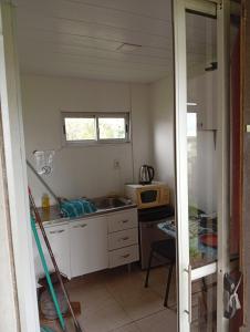 een kleine keuken met een spoelbak en een magnetron bij Apartamento La Balsa in San Gregorio de Polanco