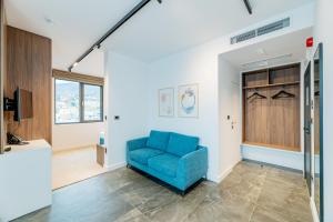 a living room with a blue couch and a tv at Novita Hotel in Sofia