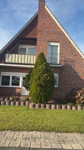 a large bush in front of a brick house at FeWo Papenburg im OG - Nähe City in Papenburg