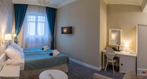 a hotel room with a bed and a desk at Dom Zdrojowy in Świeradów-Zdrój