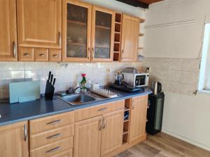 a kitchen with wooden cabinets and a sink at Chalupa Vyšní Lhoty in Vyšní Lhoty