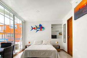 a bedroom with a bed and a large window at Quiet studio apartment one block from the beach in Playa Bello Horizonte