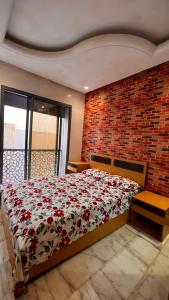 a bedroom with a bed and a brick wall at Beautiful appartement with pool view in Mohammedia