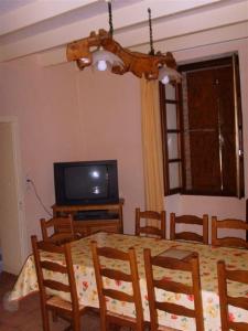 a dining room with a table and a television at La Plaine in Puygaillard-de-Quercy