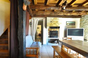un salon avec une table et une télévision dans l'établissement Gîte du hameau de Labat, à Beauregard