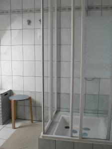 eine Duschkabine mit Hocker und Stuhl im Badezimmer in der Unterkunft Gîte les Iris in Scherwiller