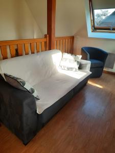 ein großes Bett in einem Zimmer mit Stuhl in der Unterkunft Gîte les Iris in Scherwiller