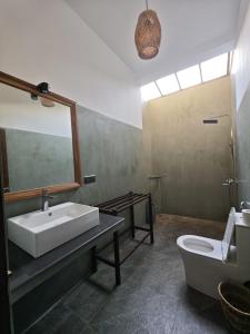 a bathroom with a sink and a toilet and a mirror at Asoka's Place in Unawatuna +11 photos