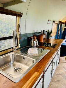 a kitchen with a sink and a counter at WildView Cosy Glamping with Outdoor Bath and stunning scenery in Helston