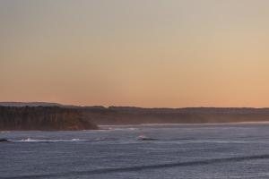 a body of water with a sunset in the background at The Beach House Bawley Point - near Bawley Beach in Bawley Point