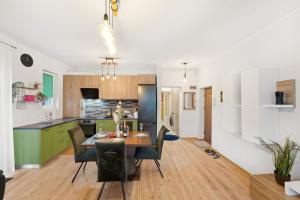 a kitchen and dining room with a table and chairs at Apartament Luna in Giroc