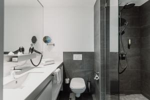 Un baño con ducha, inodoro y lavabo. en Grimms Hotel Hanau, en Hanau am Main