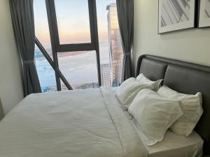 1 cama con sábanas y almohadas blancas frente a una ventana en The Peak Residence Service Apt By Hayden, en Phnom Penh 23 fotos más