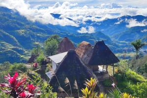 a group of huts with mountains in the background at Hiwang Native House Inn & Viewdeck in Banaue