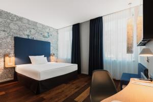 una habitación de hotel con una cama y una silla en Grimms Hotel Hanau, en Hanau am Main 55 fotos más