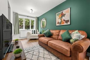 a living room with a brown leather couch at Modern 3-Bed Home, Super King Beds, Drive Parking in Birmingham