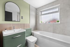 a bathroom with a sink toilet and a tub and a window at Modern 3-Bed Home, Super King Beds, Drive Parking in Birmingham +21 photos