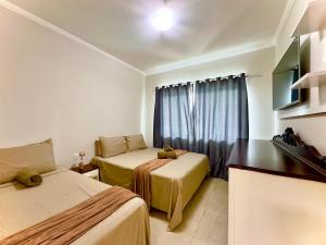 Una televisión o centro de entretenimiento en Casa Completa com Piscina Churrasqueira Wi-Fi e Garagem para 2 Carros a 250m da Praia Acomoda 6 Pessoas, com Ar-Condicionado