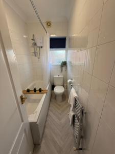 a bathroom with a tub and a toilet and a sink at Rochester House in Middlesbrough +52 photos