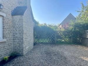 einen Zaun vor einem Backsteingebäude in der Unterkunft Cotswolds Eco House in Charlbury + 56 Fotos