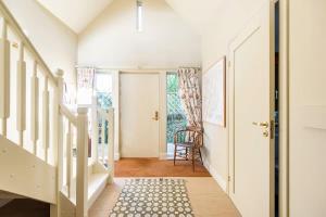 ein Flur mit einer Treppe und einem Stuhl in einem Haus in der Unterkunft Cotswolds Eco House in Charlbury